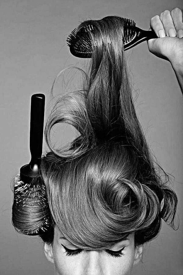 Black and white shot of long hair being brushed out with round brushes