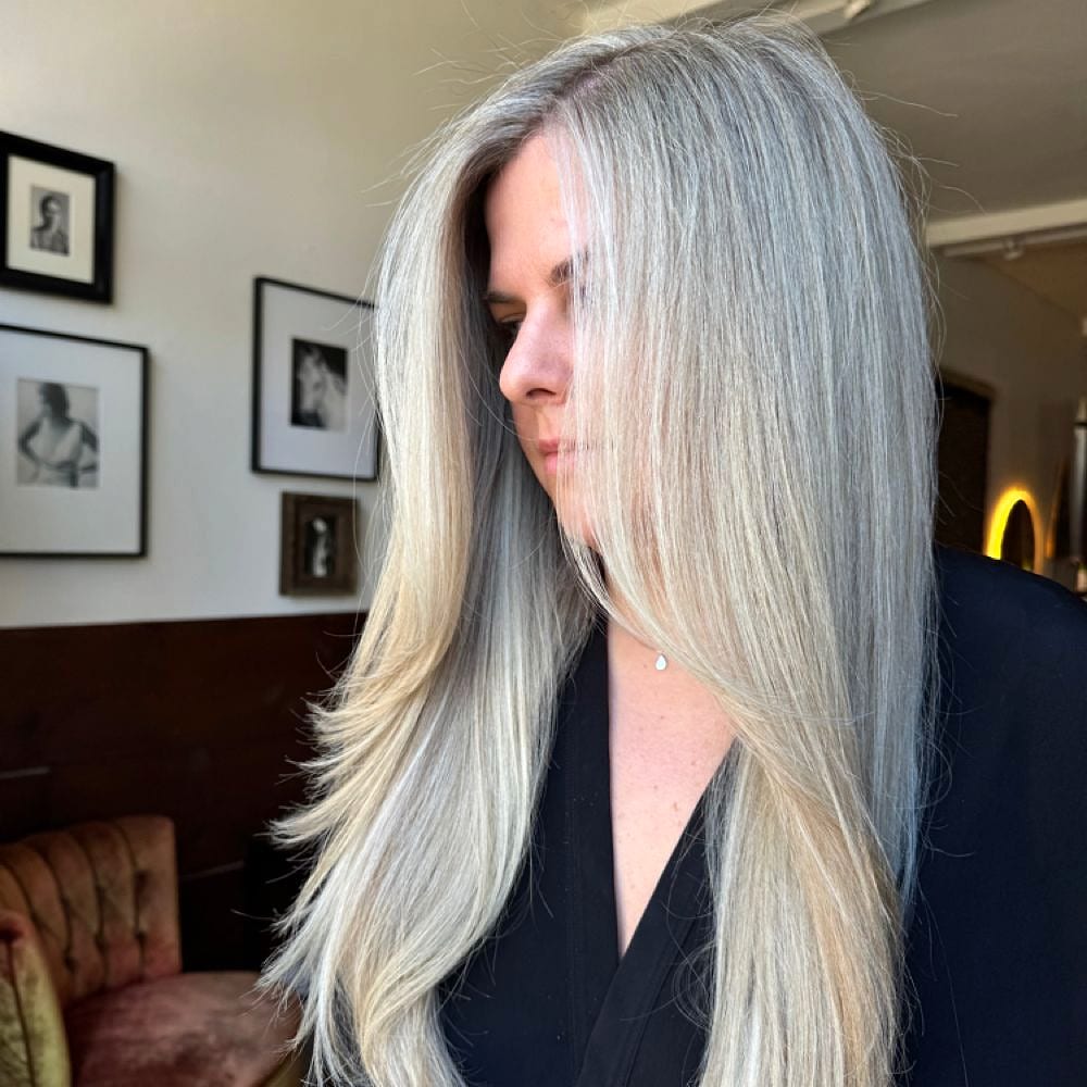 Long silver-blonde hair in profile inside the decorated salon
