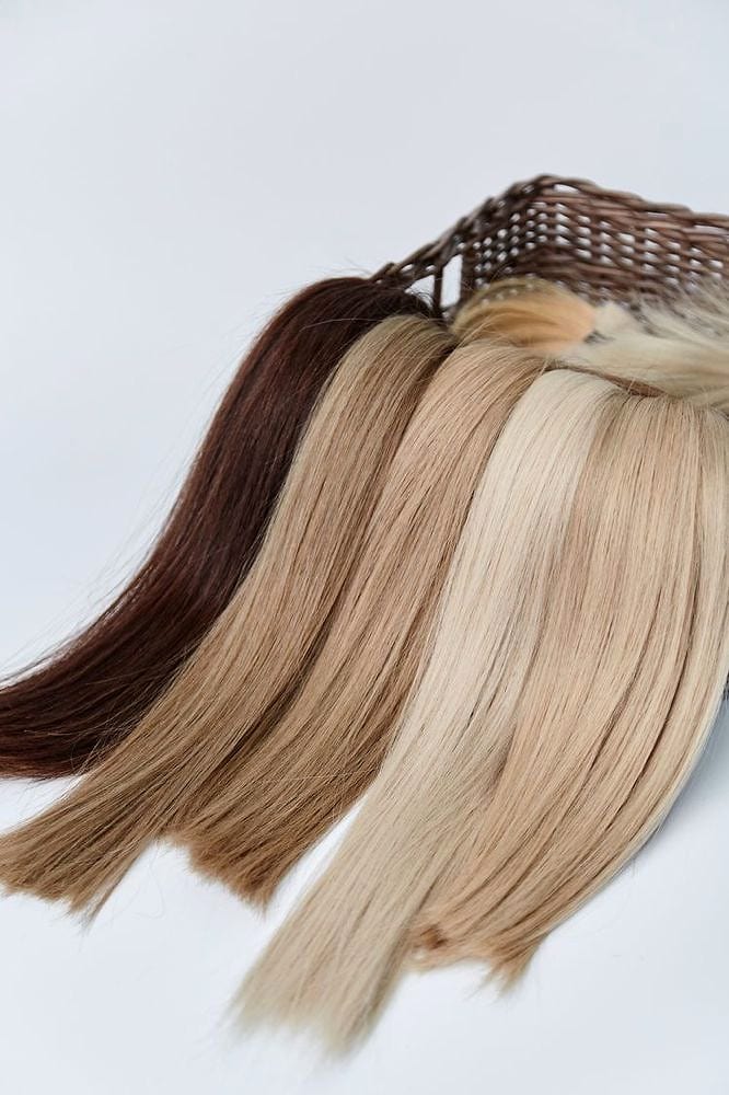 Hand-tied extension wefts in a row of shades from brown to blonde
